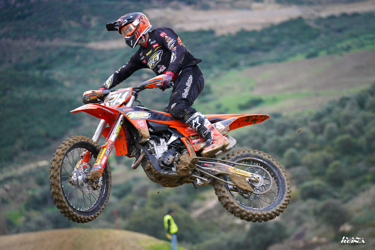 Piloto de enduro en el aire sobre un valle