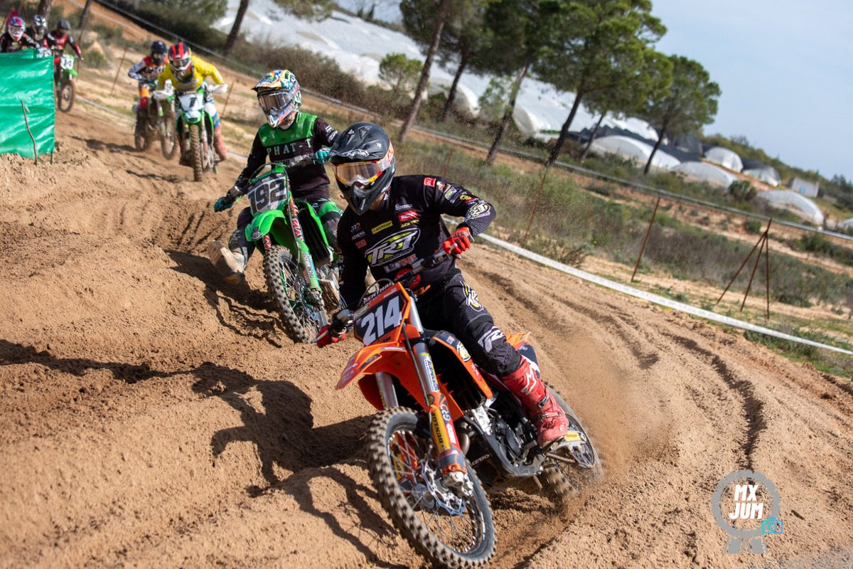 Dos pilotos peleando una curva en carrera de motocross